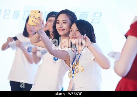 German-born Taiwanese actress Janine Chang Chun-ning takes selfies with a fan at the 10th anniversary fan meeting in Shanghai, China, 16 July 2018. Stock Photo