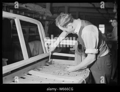 High Point, North Carolina - Upholstering. Tomlinson Chair Manufacturing Co. Webbing - Sewing in and tacking webbing - chair. Stock Photo