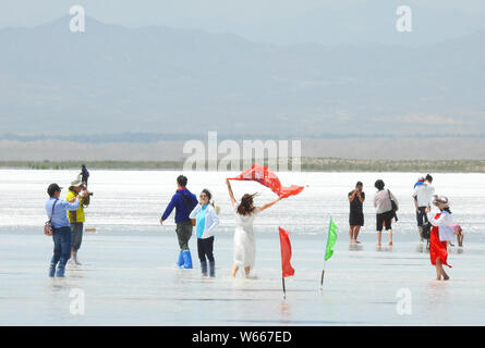 Tourists visit the Chaka Salt Lake in Ulan county, Haixi Mongol and Tibetan Autonomous Prefecture, northwest China's Qinghai province, 20 July 2018. Stock Photo