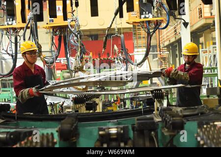 --FILE--Chinese workers assemble a truck on the assembly line at the ...