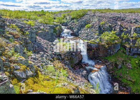 Waterfall on a rocky mountainside in a beautiful landscape Stock Photo
