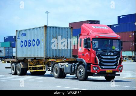 --FILE--A truck transports a container of COSCO Shipping to be shipped abroad on a quay at the Port of Qingdao in Qingdao city, east China's Shandong Stock Photo