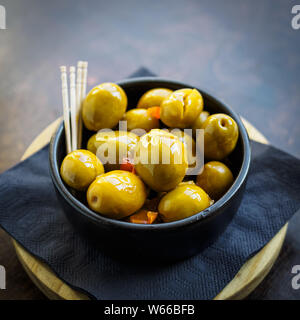 Green spicy olives spanish tapa on a black bowl Stock Photo