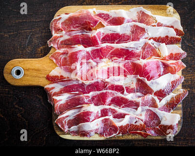 Iberico ham cut on a wooden board, spanish typical tapa Stock Photo