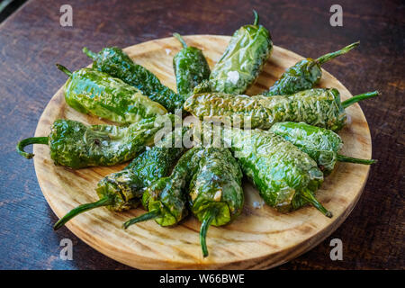 Fried Padron peppers tapa on a wooden board Stock Photo