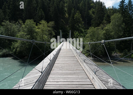 modern wooden suspension bridge over the river Rhine in the Ruinaulta Gorge in the Swiss Alps Stock Photo