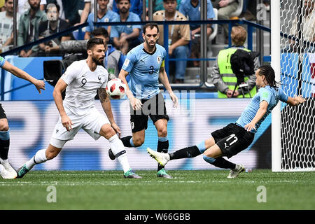 Diego Laxalt, right, of Uruguay passes the ball against Olivier Giroud of France in their quarterfinal match during the 2018 FIFA World Cup in Nizhny Stock Photo