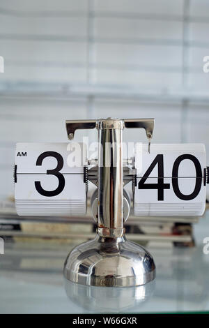 Classic flip clock on a metal stand in the interior.The theme of time and punctuality. Stock Photo