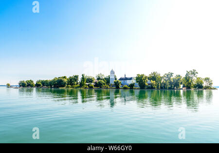 Fraueninsel, Frauenchiemsee on lake Chiemsee in the  morning sunrise with boat, Sailboat, church, monastery. Bavaria, Bayern, Germany Stock Photo