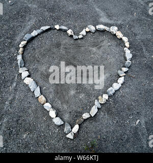 square view of a heart made of colorful stones on sandy ground Stock Photo