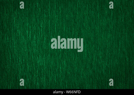 Abstract texture of a rough dark green paper background and copy space for text. Macro fiber paper. Stock Photo