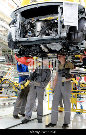 Chinese workers assemble cars on the assembly line at the auto plant of ...