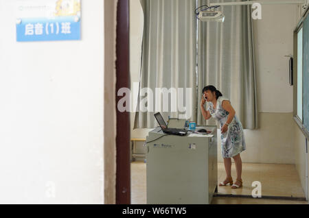 (190731) -- NANCHANG, July 31, 2019 (Xinhua) -- Liu Xiaoqing is pictured during class hour at the Luxi County Special Education School in Luxi County of Pingxiang, east China's Jiangxi Province, July 3, 2019. When the Luxi County Special Education School was established in 1997, Liu Xiaoqing, then a normal university graduate, applied for a post there without hesitation.   Working as a special education teacher has been challenging, as Liu's students need far more attention than their peers without physical or mental disabilities. But Liu stayed on her post for 22 years helping her students im Stock Photo