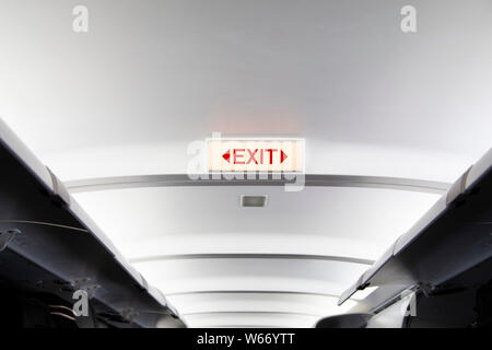 Exit sign on the ceiling of an aeroplane Stock Photo