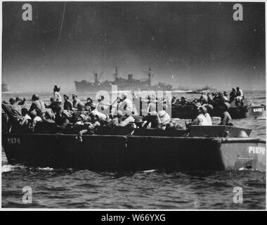 Landing barges loaded with troops sweep toward the beaches of Leyte Island as American and Japanese planes duel to the death overhead. Troops watch the drama being written in the skies as they approach the hellfire on the shore.; General notes:  Use War and Conflict Number 1205 when ordering a reproduction or requesting information about this image. Stock Photo