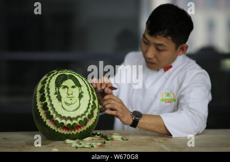 Chinese teacher Jiang Zhongmin shows watermelon carvings of Argentine football player Lionel Messi in Shenyang city, northeast China's Liaoning provin Stock Photo