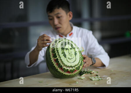 Chinese teacher Jiang Zhongmin shows watermelon carvings of Argentine football player Lionel Messi in Shenyang city, northeast China's Liaoning provin Stock Photo