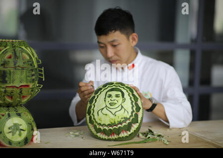 Chinese teacher Jiang Zhongmin shows watermelon carvings of French football player Kylian Mbappe in Shenyang city, northeast China's Liaoning province Stock Photo