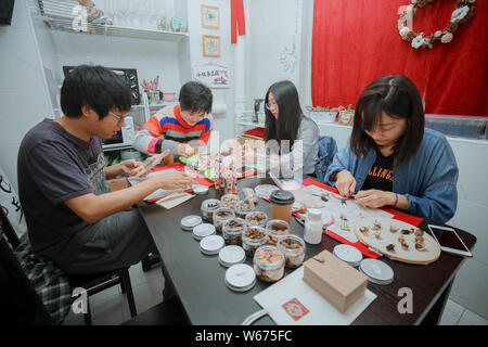 --FILE--A Chinese DIY enthusiast Xiaobei, second left, teaches customers to create artworks at her workshop in Beijing, China, 21 April 2018.   As mac Stock Photo