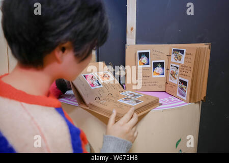 --FILE--A Chinese DIY enthusiast Xiaobei looks at photos of artworks created by her customers at her workshop in Beijing, China, 21 April 2018.   As m Stock Photo