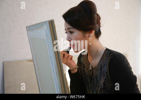 --FILE--26-year-old Chinese girl Liang Xiaoqing from Beijing finishes her hair and makeup before posing for photos for clothing brands that targets el Stock Photo