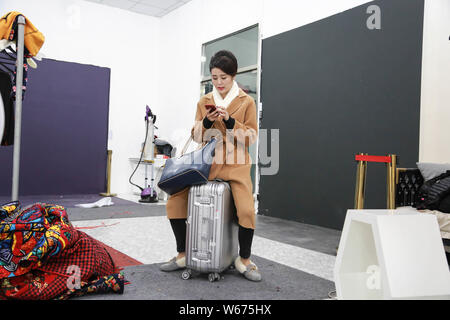 --FILE--26-year-old Chinese girl Liang Xiaoqing from Beijing finishes her hair and makeup before posing for photos for clothing brands that targets el Stock Photo