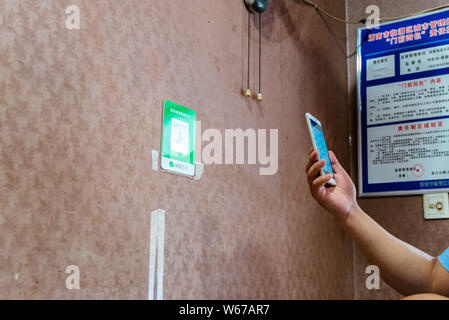 --FILE--A customer uses her smartphone to scan the QR code of WeChat Payment of the messaging app Weixin, or WeChat, of Tencent to pay her purchase in Stock Photo