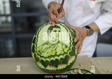 Chinese teacher Jiang Zhongmin shows watermelon carvings of Portuguese football player Cristiano Ronaldo in Shenyang city, northeast China's Liaoning Stock Photo