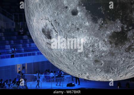 Visitors view a huge moon model during an exhibition on moon held at the National Aquatic Center or 'Water Cube' in Beijing, China, 8 July 2018.    A Stock Photo