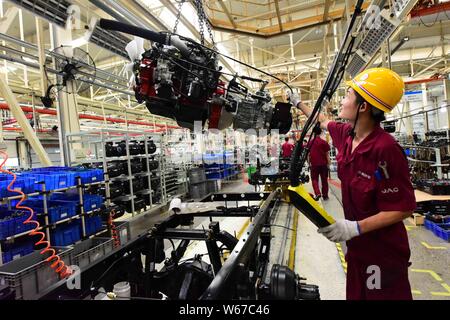 --FILE--A Chinese worker assembles a car engine on the assembly line at ...