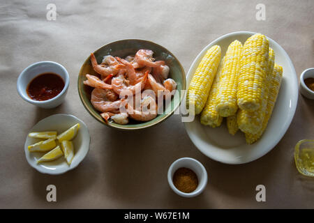 Steamed shrimp and hot fresh corn on the cobb, with trimmings. Stock Photo