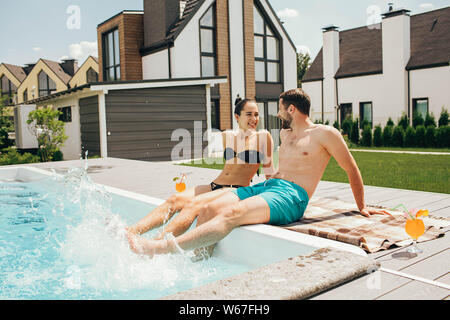 man and a woman look lovingly at each other while in the pool. Goodbye work, hi summer vacation-swimming and tanning Stock Photo