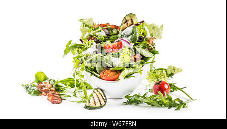 Fresh vegetable salad with fried bacon tomatoes olives arugula zucchini tzatziki dressing and olive oil isolated on white background. Stock Photo