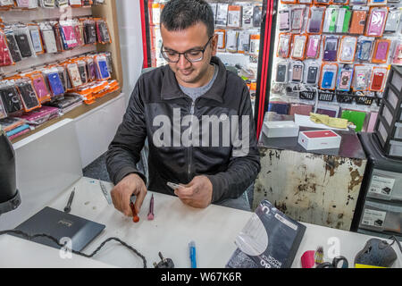 Technician working on a faulty mobile telephone. Stock Photo