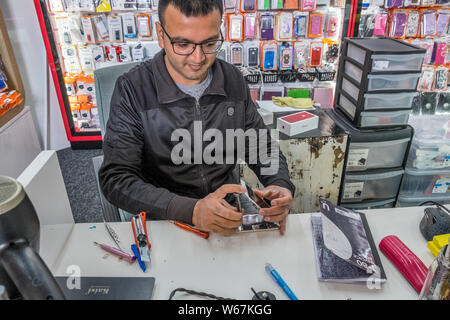 Technician working on a faulty mobile telephone. Stock Photo