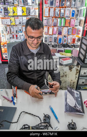 Technician working on a faulty mobile telephone. Stock Photo