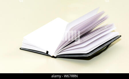 open hardcover notebook on a white table. Unwritten blank pages. Stock Photo