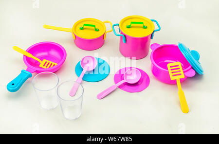 Set of children's toy colorful dishes isolated on white background. Kid toy utensil for girls game Stock Photo