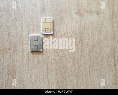 two micro sim cards on a wooden surface backgrounds Stock Photo