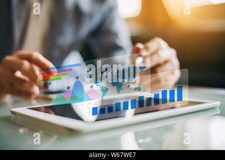 Businessman investor analyzing company financial mutual fund report working with digital augmented reality graphics technology. Concept for business, Stock Photo