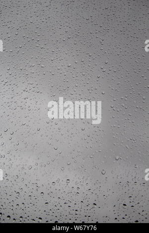 Raindrops on window-pane blurred background Stock Photo