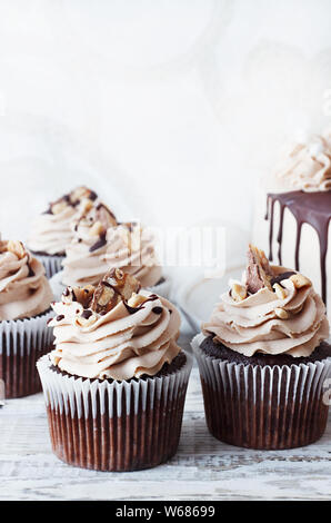 Chocolate cupcake with chocolate mousse cream icing on grunge white wooden background Stock Photo