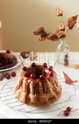 Apple pie with nuts, decorated with salted caramel and small red apples. Rustic style. Stock Photo