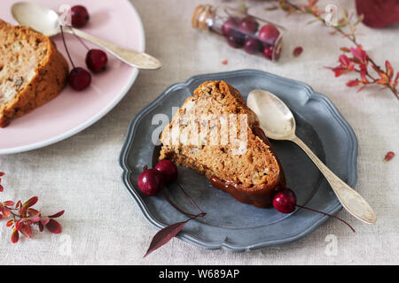 Apple pie with nuts, decorated with salted caramel and small red apples. Rustic style. Stock Photo