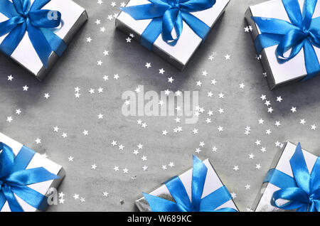 Gift boxes with blue ribbon on grey background with star. Top view. Stock Photo