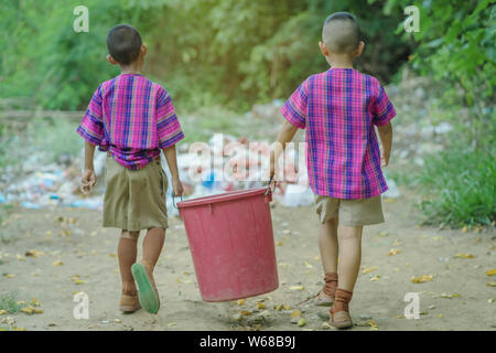 Male Students help to remove rubbish from the classroom to pile waste Stock Photo