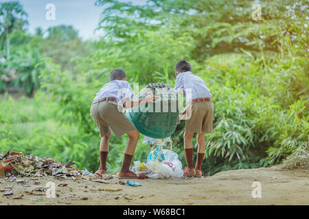 Male Students help to remove rubbish from the classroom to pile waste Stock Photo