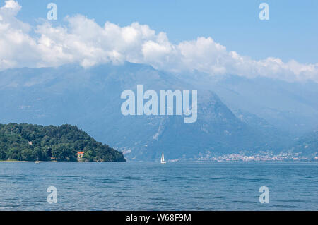 View of mountain lake and the pomontory on a sunny summer day. District of Como Lake, Colico, Italy, Europe. Stock Photo