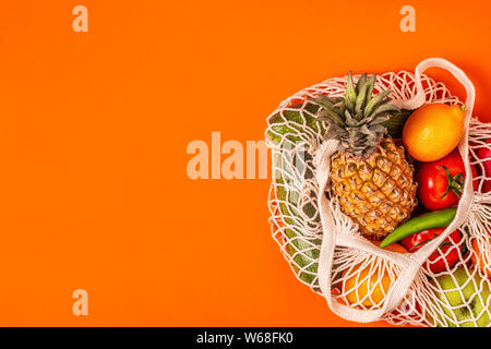Fresh vegetables and fruits in bag mesh, top view. Stock Photo