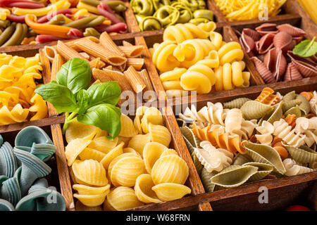 Assorted colorful italian pasta in wooden box Stock Photo